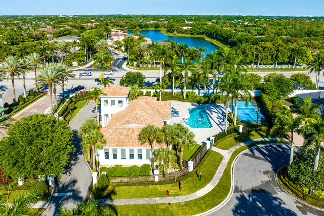 a view of a swimming pool with a patio and palm trees