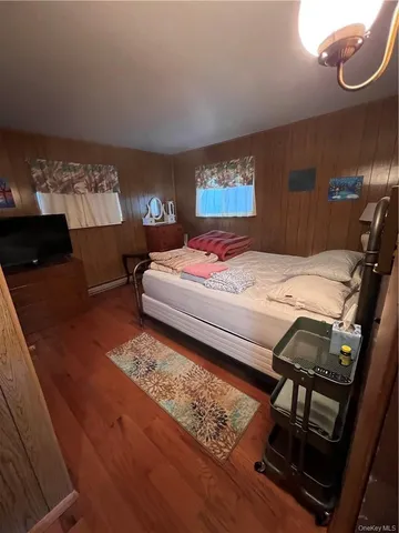 a bedroom with a bed a dresser and window