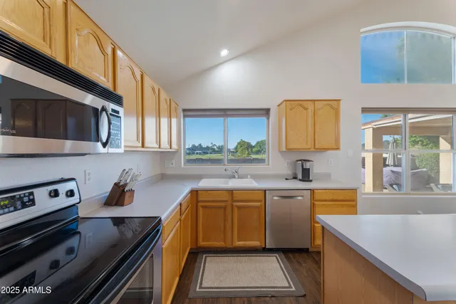 a kitchen with a sink a stove cabinets and a window