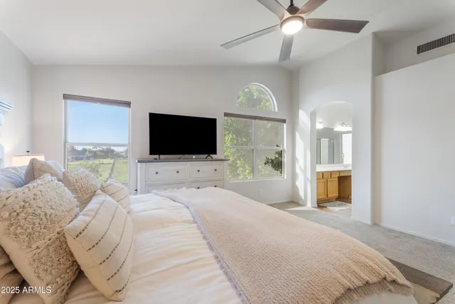 a spacious bedroom with a large bed and a flat screen tv