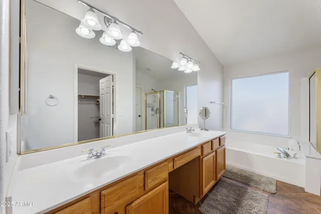 a spacious bathroom with a granite countertop sink a mirror and a bathtub
