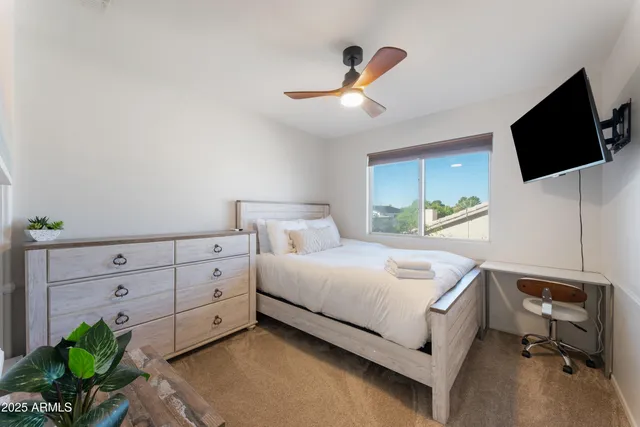 a bedroom with a bed and a flat screen tv