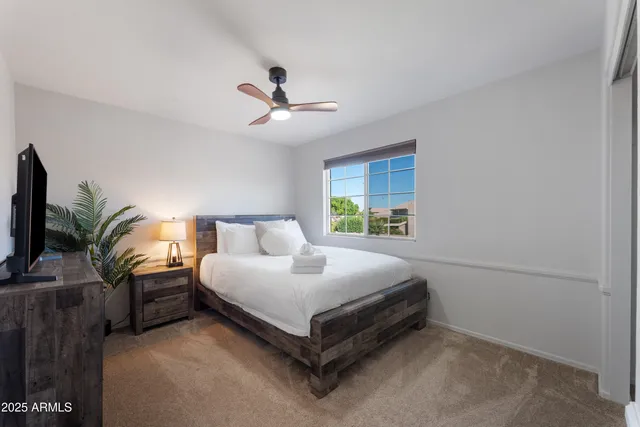 a bedroom with a bed lamp and a potted plant