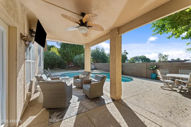 a view of a patio with a table chairs and a floor to ceiling window