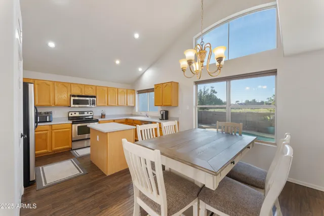 a kitchen with a table chairs microwave and cabinets