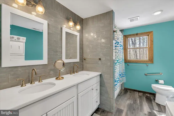 a bathroom with a double vanity sink toilet and a mirror