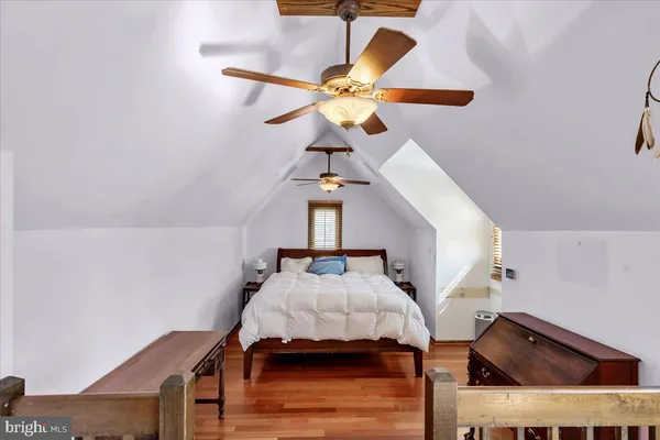 a bedroom with a bed and a chandelier fan