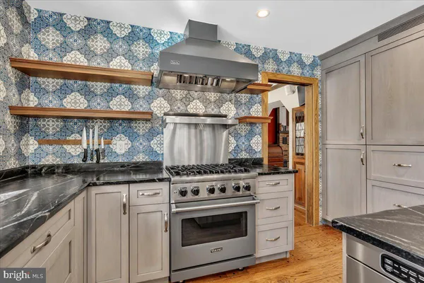 a kitchen with stainless steel appliances granite countertop a stove and a microwave