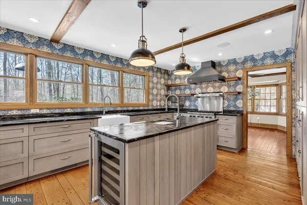 a kitchen with stainless steel appliances granite countertop a sink a stove and a wooden floors