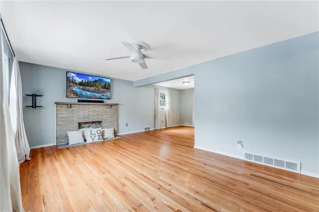 a view of empty room with fireplace and wooden floor