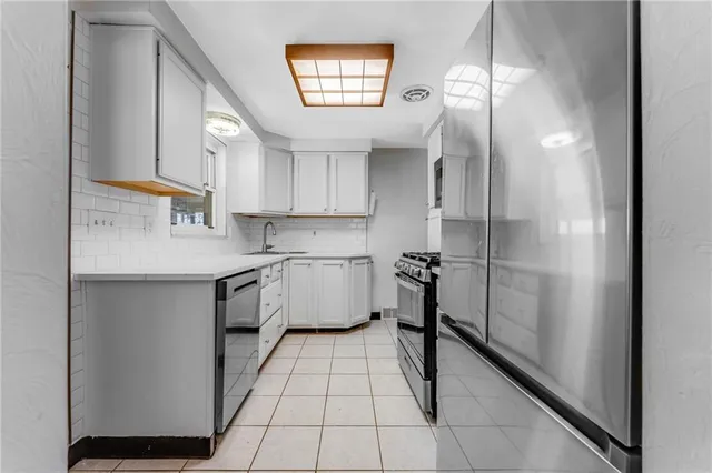 a kitchen with a refrigerator a sink and cabinets