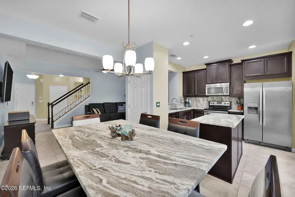 a large kitchen with kitchen island granite countertop a large counter top stainless steel appliances a sink and cabinets