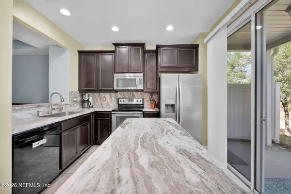 a kitchen with stainless steel appliances granite countertop a sink stove and microwave