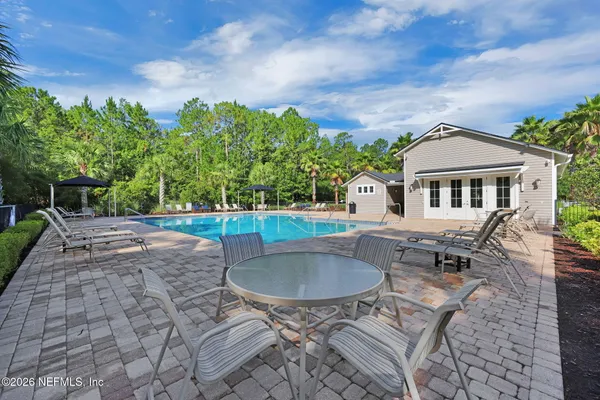 a view of house with swimming pool and yard