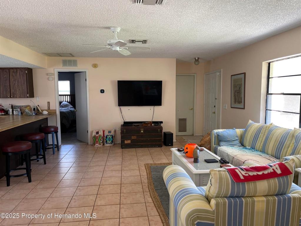 6233 Hancock Avenue Spring Hill, FL 34608 - Photo 2 of 19 a living room with furniture and a flat screen tv
