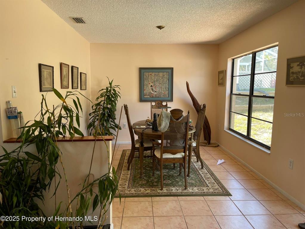 6233 Hancock Avenue Spring Hill, FL 34608 - Photo 5 of 19 a view of a dining room with furniture and a window
