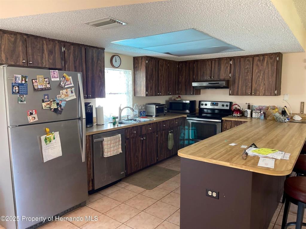 6233 Hancock Avenue Spring Hill, FL 34608 - Photo 6 of 19 a kitchen with stainless steel appliances granite countertop a refrigerator a sink a stove a cabinets and a refrigerator