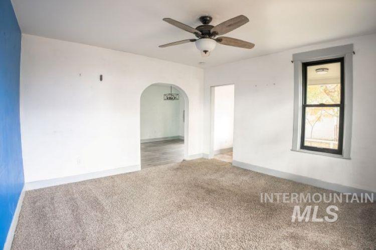 622 West Commercial Street Weiser, ID 83672 - Photo 6 of 21 Carpeted spare room featuring arched walkways and a ceiling fan