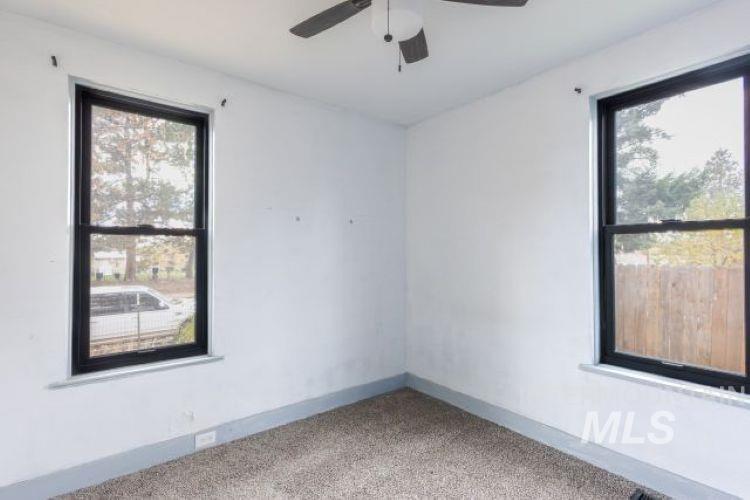 622 West Commercial Street Weiser, ID 83672 - Photo 9 of 21 Empty room with carpet floors, healthy amount of natural light, and a ceiling fan