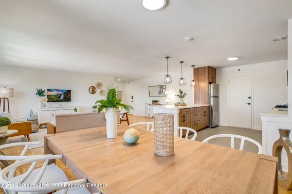 a kitchen with stainless steel appliances kitchen island granite countertop a table chairs and a view of living room