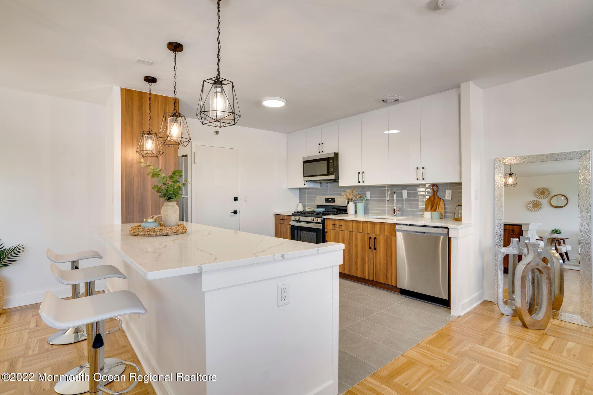 122 Bodman Place, Unit 6B Red Bank, NJ 07701 - Photo 15 of 30 a kitchen that has a lot of white cabinets and stainless steel appliances