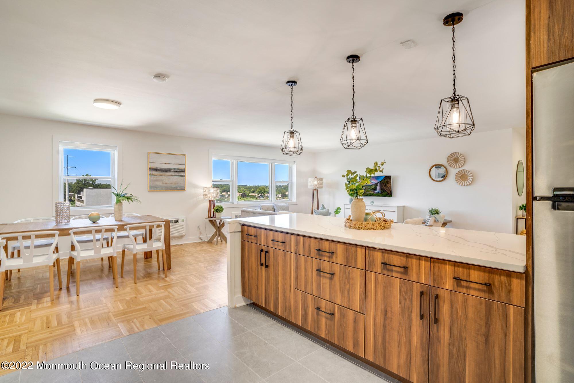 122 Bodman Place, Unit 6B Red Bank, NJ 07701 - Photo 17 of 30 a kitchen with stainless steel appliances kitchen island granite countertop a table chairs and a view of living room