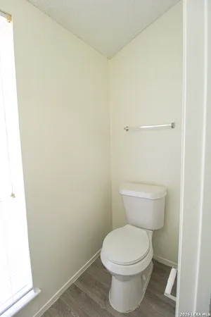 a white toilet sitting next to a small window