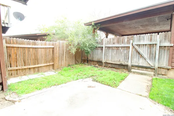 a backyard of a house with a garden and barbeque oven