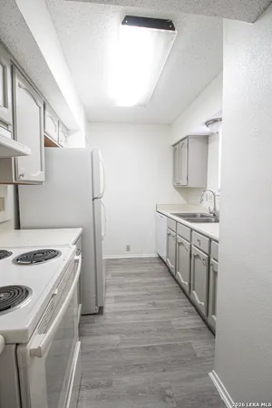 a kitchen with a stove sink and a refrigerator