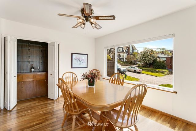 a dining room with furniture a flat screen tv and a floor to ceiling window