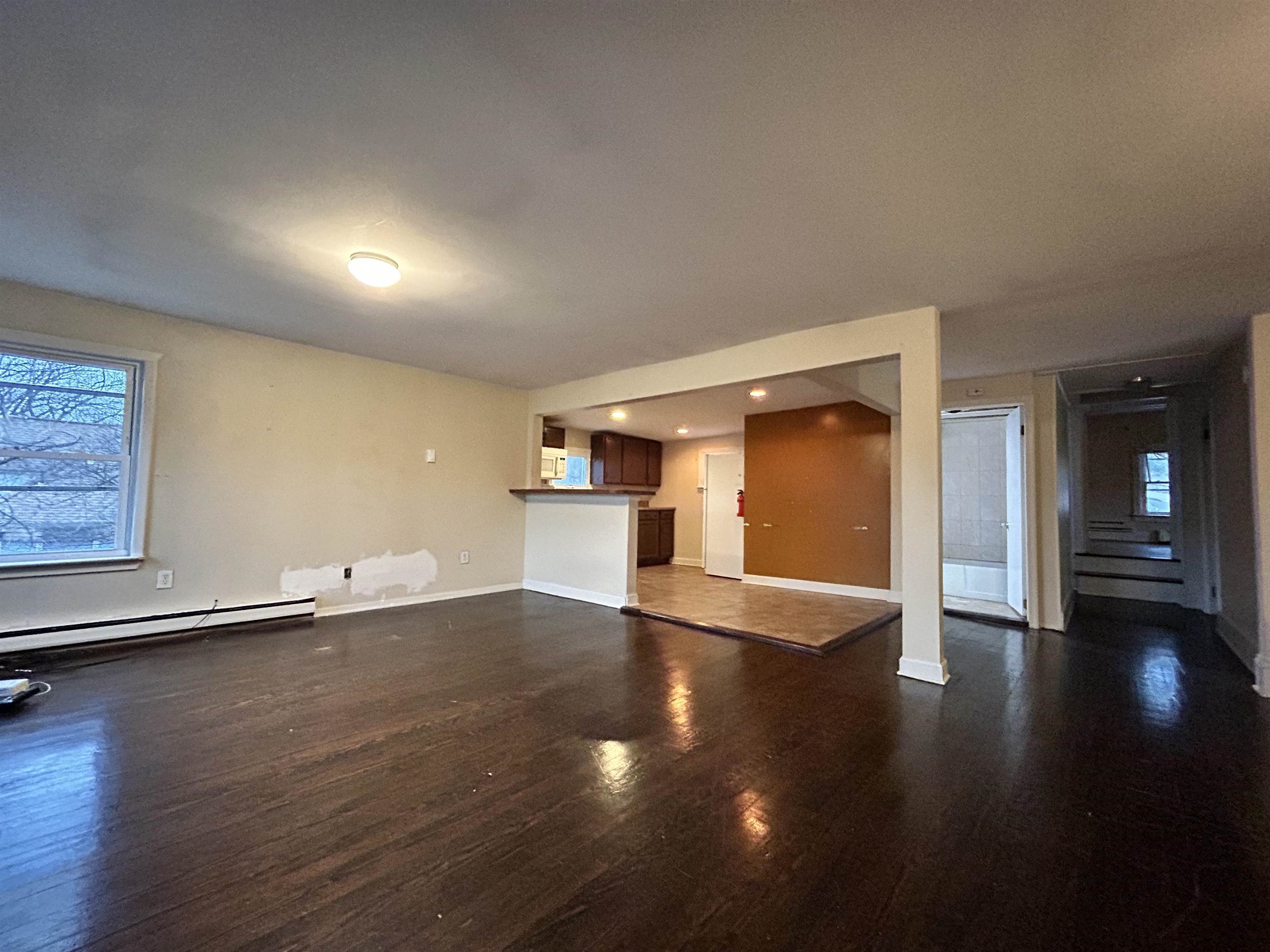 86 South Morris Street, Unit B Dover, NJ 07801 - Photo 3 of 11 an empty room with wooden floor and windows