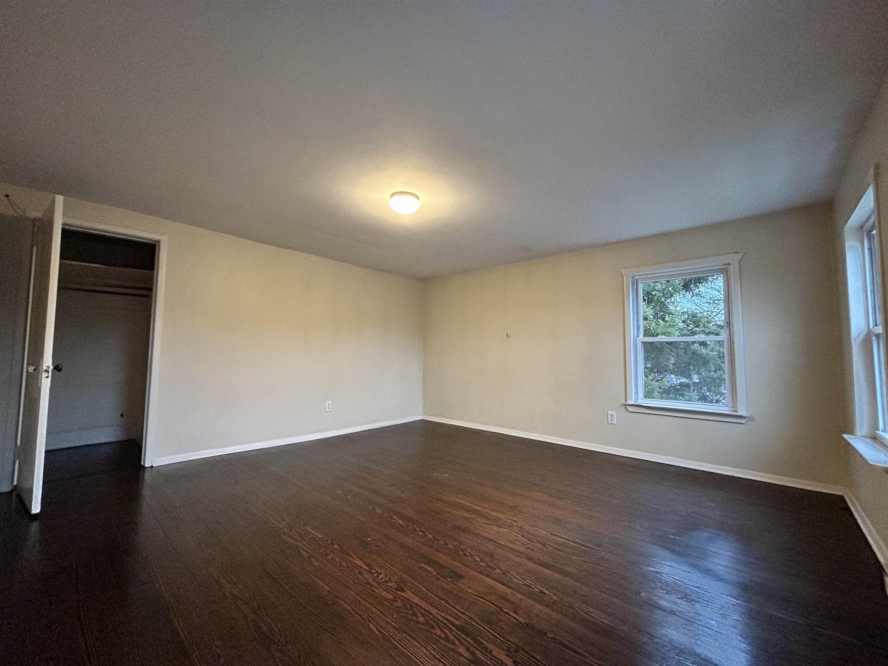 86 South Morris Street, Unit B Dover, NJ 07801 - Photo 8 of 11 a view of an empty room with wooden floor and a window