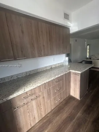 a kitchen with granite countertop a sink a stove and cabinets