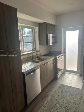 a kitchen with stainless steel appliances granite countertop a sink stove and refrigerator