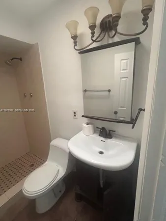 a bathroom with a sink a toilet and mirror