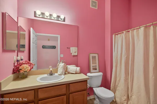 a bathroom with a sink vanity mirror and toilet
