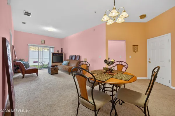 a view of a dining room with furniture and chandelier