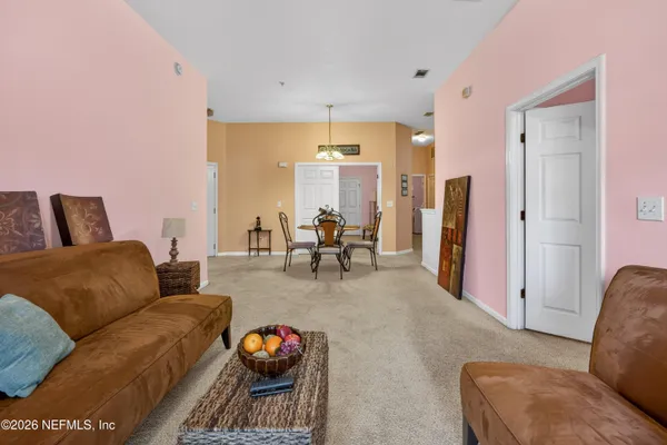 a living room with furniture a rug and white walls