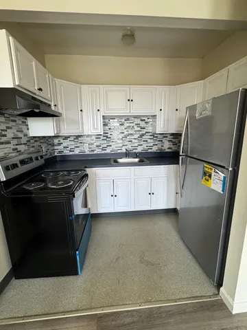 a kitchen with granite countertop a stove and a sink