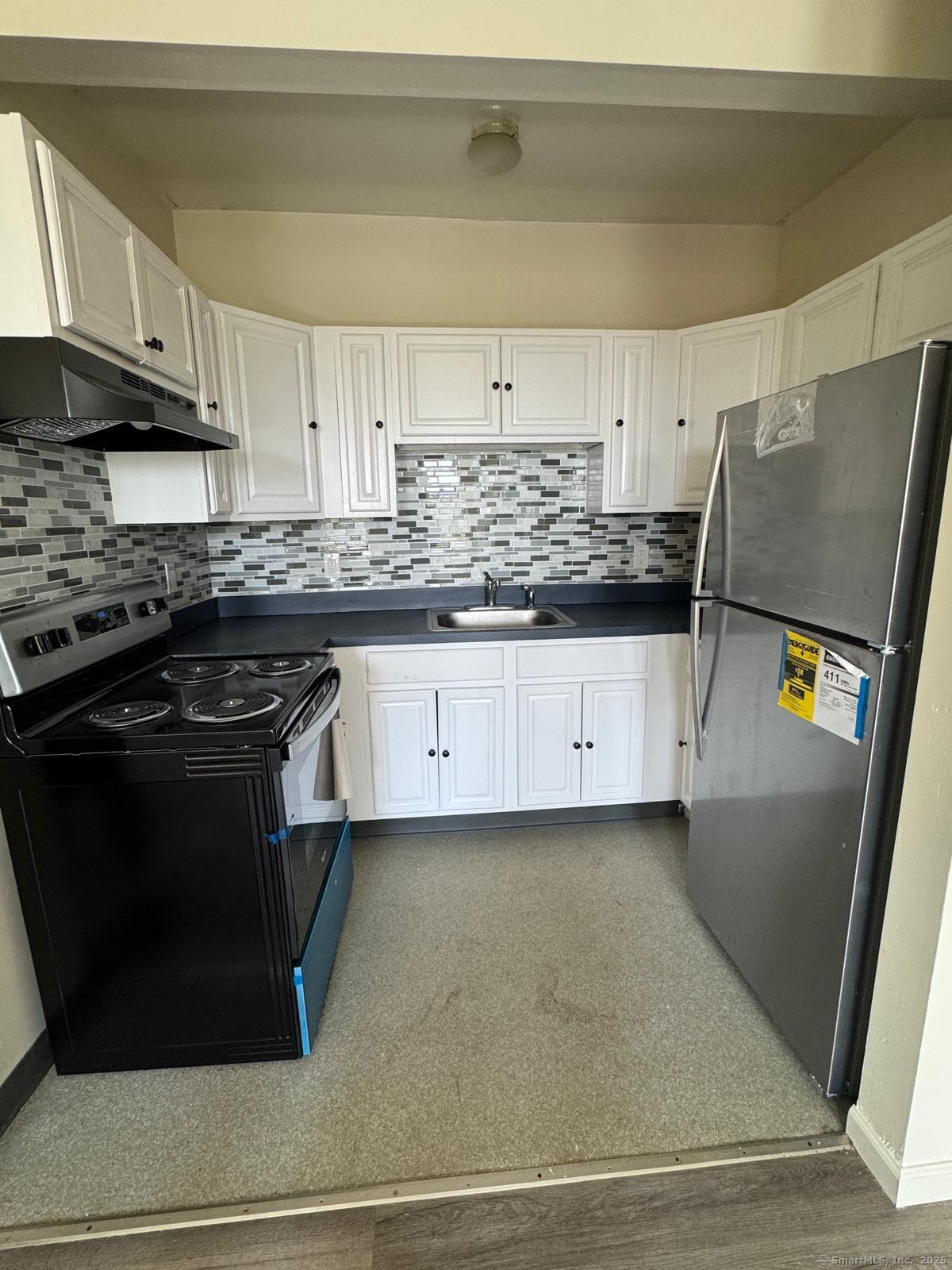 1053 East Main Street Bridgeport, CT 06608 - Photo 1 of 6 a kitchen with granite countertop a stove and a sink