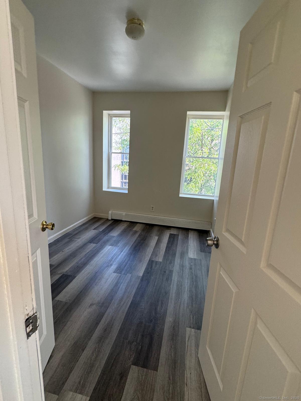 1053 East Main Street Bridgeport, CT 06608 - Photo 2 of 6 wooden floor in an empty room with a window