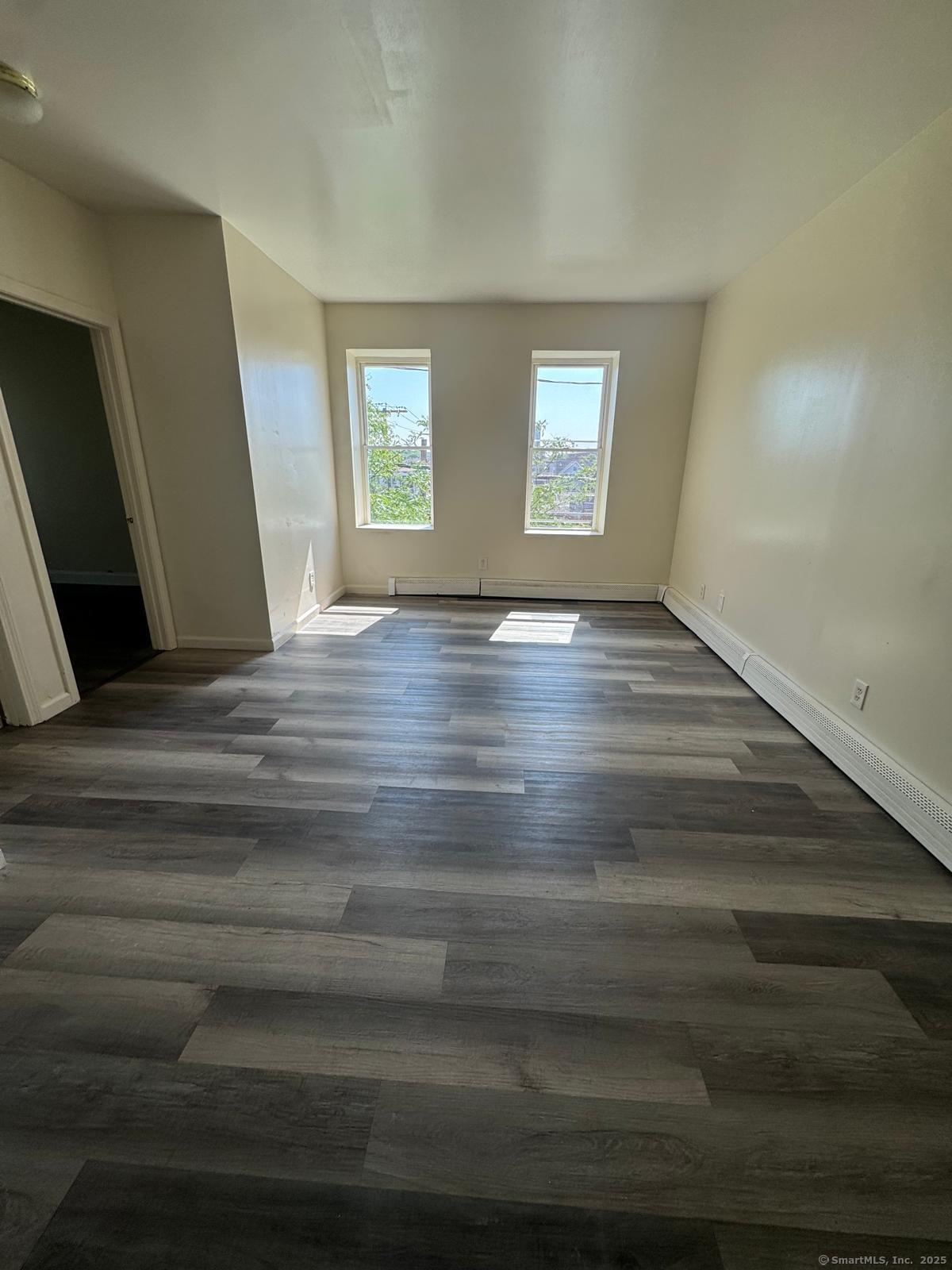 1053 East Main Street Bridgeport, CT 06608 - Photo 3 of 6 a view of an empty room with window and wooden floor