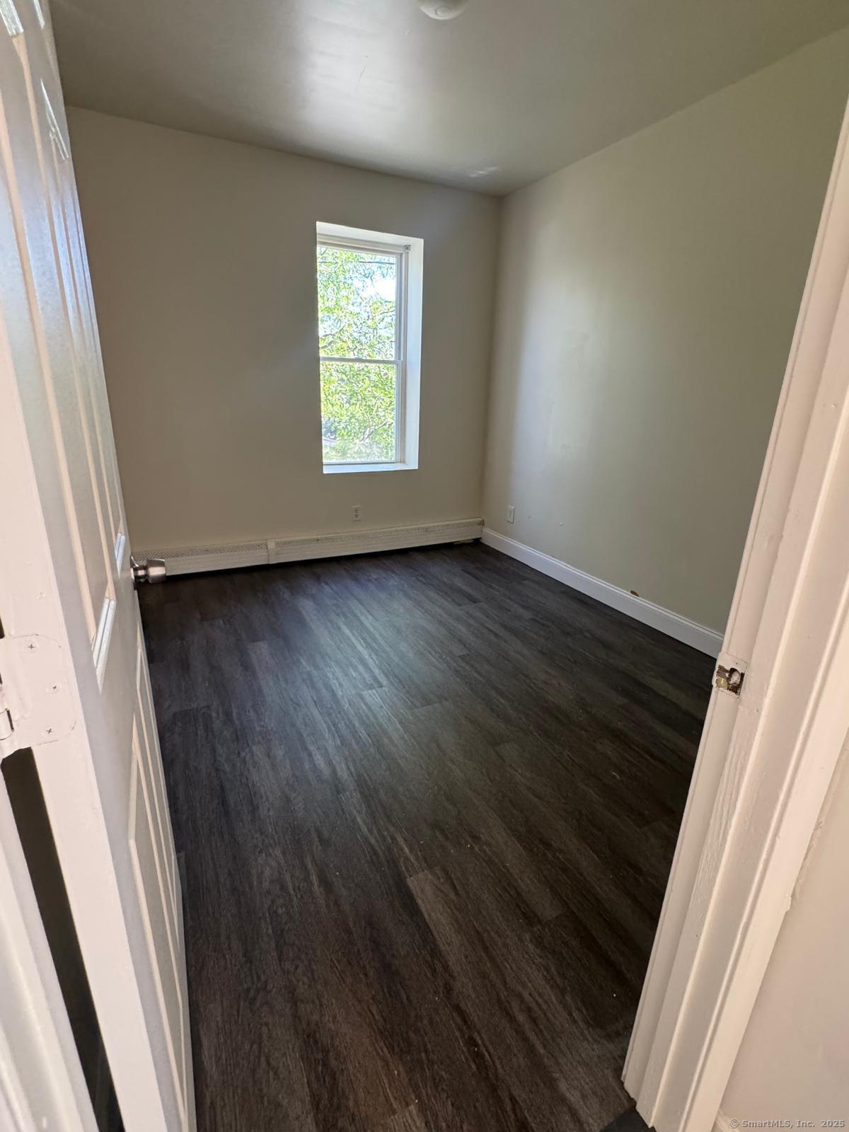 1053 East Main Street Bridgeport, CT 06608 - Photo 4 of 6 an empty room with wooden floor and windows