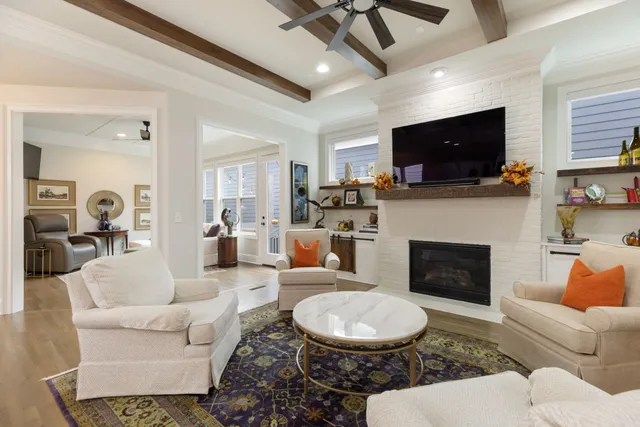 a kitchen with stainless steel appliances kitchen island granite countertop a stove a sink a refrigerator and white cabinets with wooden floor