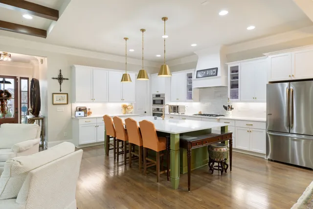 a living room with furniture large window and wooden floor