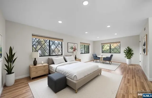 a bedroom with a large bed and a potted plant