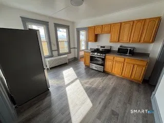 a kitchen with granite countertop wooden cabinets a sink a window and stainless steel appliances