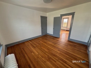 14 Guilfoile Street, Unit 2 Waterbury, CT 06708 - Photo 9 of 17 a view of an empty room with wooden floor and a window