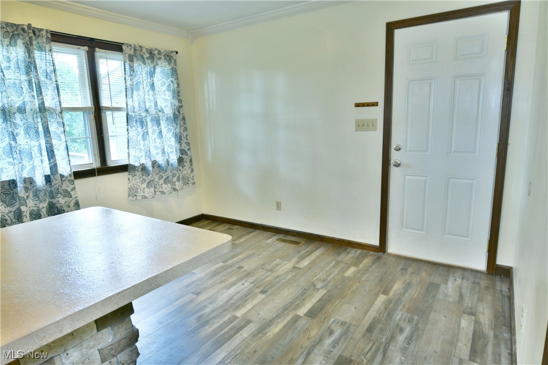 1141 Howell Road East Palestine, OH 44413 - Photo 19 of 41 Unfurnished dining area with light wood-style flooring and ornamental molding