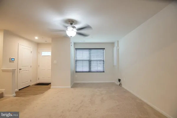 an empty room with a ceiling fan and a window